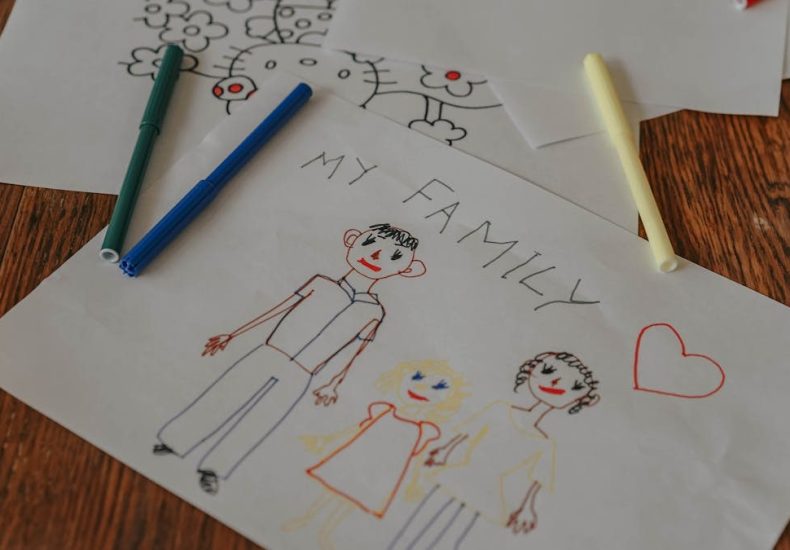 A hand-drawn family portrait using colored markers on paper, showcasing creativity and love.