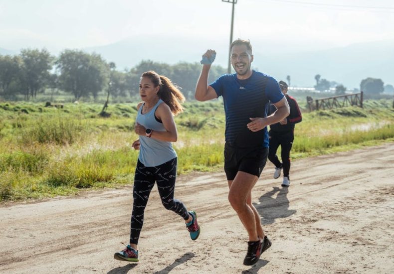 A group of runners enjoys a vibrant morning jog on a rural dirt road.